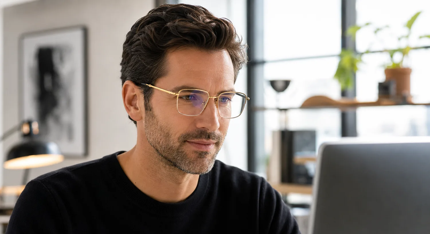 Hombre con anteojos ópticos trabajando frente a una computadora