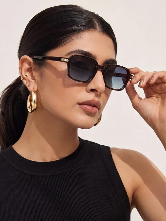 Mujer con anteojos de sol de marco oscuro en un retrato editorial
